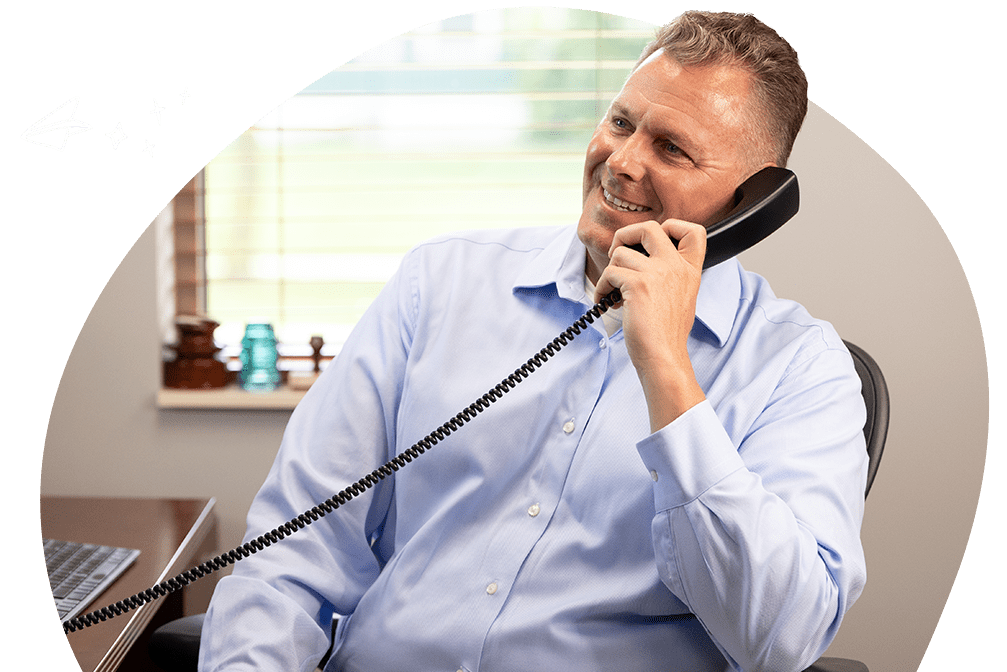 aaron boatin president of ambs call center smiling while answering a call